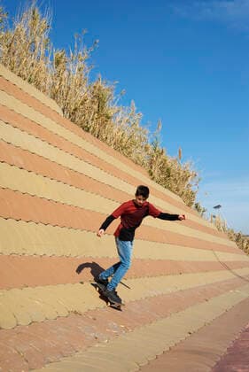Young boy skateboarding on ramp in a city park in sunny day Barcelona, CT, Spain CR_RAFE200103D-132359-01