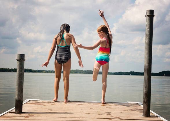 Two Young Girls in Swimsuits About to Jump off a Dock Into a Lake Independence, MN, United States CR_RDOL200102-258753-01