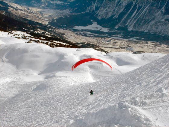 IMAGO Creative: Sport Dichotomien - Land und Wasser Parasailing in Swiss Alps mountains Aerial view of single person parasailing in Swiss Alps mountains.  Copyright: xspeedfighterx 1199323