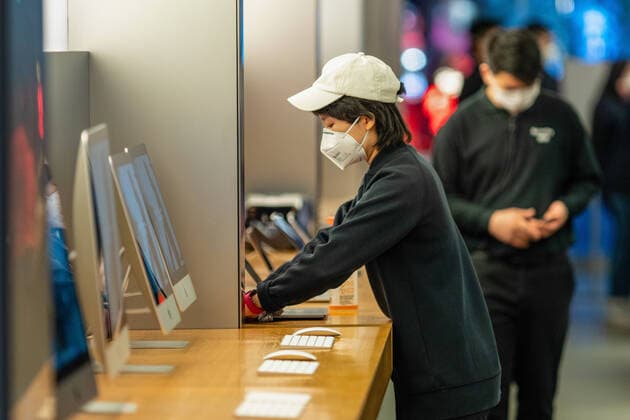 BEIJING, CHINA - FEBRUARY 1, 2020: People in face masks in an Apple store during an outbreak of the 2019-nCoV coronavirus, which started in Wuhan in December 2019; according to recent data, the number of people infected with the new strain of coronavirus has risen over 14,000, with the death toll reaching 305. Artyom Ivanov TASS  TS0CCA4A