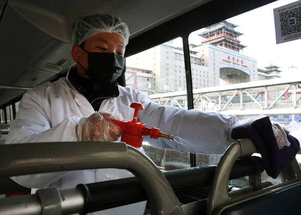 (200203) -- BEIJING, Feb. 3, 2020 -- A staff member disinfects a bus handrail at a bus station in Beijing, capital of China, Feb. 3, 2020. Monday marks the first working day after the Spring Festival holidays for Beijing. Beijing Public Transport Corporation has taken measures such as cleaning and disinfecting buses, ventilating the air, measuring the temperatures of staff members and ensuring staffs working with face masks to prevent the spread of novel coronavirus. ) CHINA-BEIJING-CORONAVIRUS-PUBLIC TRANSPORT-PREVENTION (CN) RenxChao 