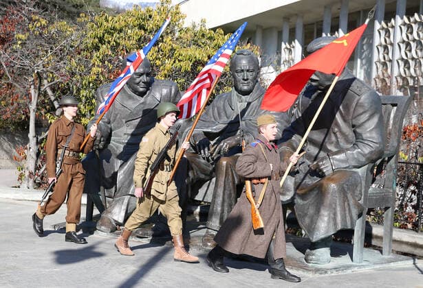 YALTA, RUSSIA - FEBRUARY 4, 2020: Participants dressed as WWII soldiers with the flags of the United Kingdom, the United States and the Soviet Union walk past a monument to the Big Three - UK Prime Minister Winston Churchill, US President Franklin Roosevelt, and Soviet leader Joseph Stalin - at Livadia Palace; Russia is celebrating the 75th anniversary of the Yalta Conference (also known as the Crimean Conference), which was attended by the three leaders of the Allied nations in 4-11 February 1945, before the end of WWII. Sergei Malgavko TASS  TS0CCD79