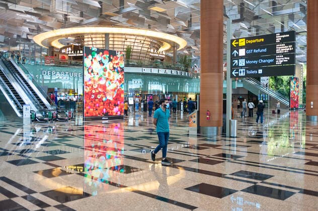 31.01.2020, Singapur, Republik Singapur, Asien - Ein Mann geht durch die Abflughalle des Terminal 3 am Flughafen Changi und traegt eine Atemschutzmaske, um sich vor einer Ansteckung mit dem Coronavirus zu schuetzen.