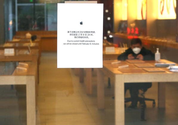 A Chinese security guard wearing a protective face mask sits in Apple s flagship store, which is closed due to the coronavirus alert, in Beijing on Tuesday, February 4, 2020. Apple has closed all of its retail stores across China due to the coronavirus health threat.  PEK2020020402 STEPHENxSHAVER