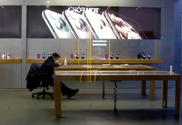 A Chinese security guard wearing a protective face mask sits in Apple s flagship store, which is closed due to the coronavirus alert, in Beijing on Tuesday, February 4, 2020. Apple has closed all of its retail stores across China due to the coronavirus health threat.  PEK2020020407 STEPHENxSHAVER