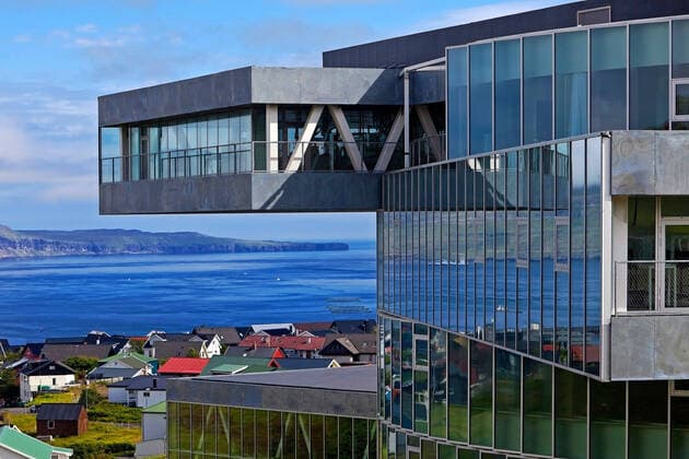 Moderne Architektur des Glasir Tórshavn College vor traditionellen Haeusern mit dem Blick auf den Atlantik, Faeroeer, Streymoy, Torshavn modern architecture of Glasir Tórshavn College in front of traditional Houses, Faroe Islands, Streymoy, Torshavn BLWS604614 Copyright: xblickwinkel S.xZiesex
