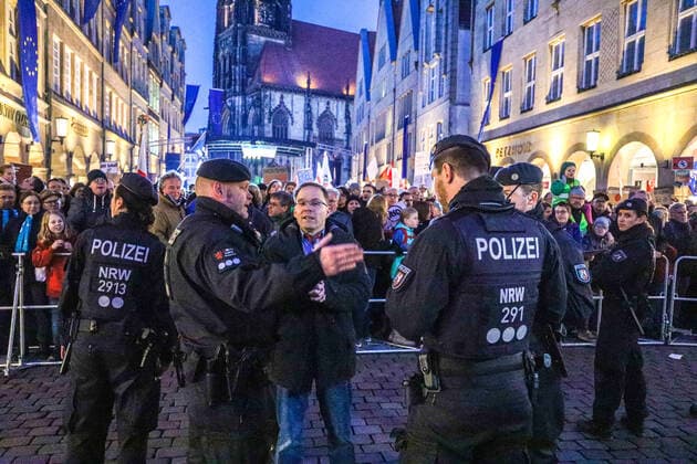 DEU, Deutschland, Nordrhein-Westfalen, Münster, 07.02.2020: Demonstration auf dem Prinzipalmarkt gegen den Neujahrsempfang der AfD Münster im Rathaus. Rund um das Rathaus finden mehrere Demonstrationen und Mahnwachen statt zu denen nach Polizeiangaben rund 4000 Teilnehmer erschienen sind. Dr. Christian Blex, MdL der AfD im Landtag von Nordrhein-Westfalen im Gespräch mit Polizeibeamten