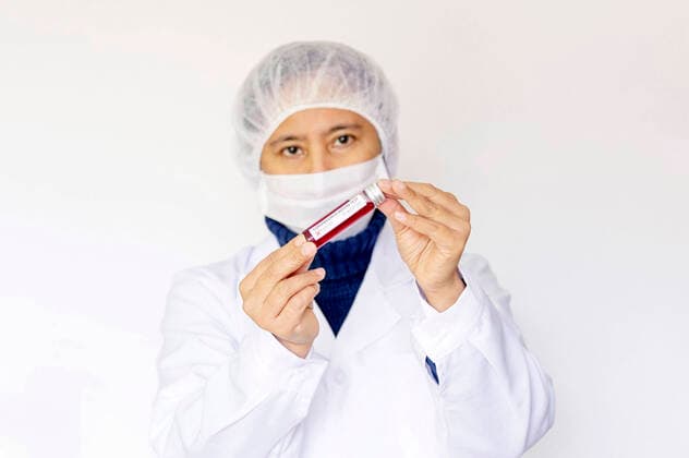 Blutprobe in einem Reagenzglas zur Analyse des Coronavirus und zur Herstellung einen Impstoffs (Model mit Attrappe, Dummy)