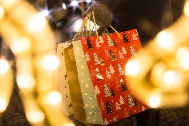 Frau mit Weihnachtstüten und Weihnachtsbeleuchtung in Berlin (Symbolfoto) *** Woman with christmas bags and christmas lights in Berlin symbol photo