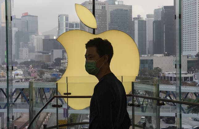 February 12, 2020, Hong Kong, China: An employee stands in front of an American multinational technology company logo and store Apple in Hong Kong. Hong Kong China - ZUMAs197 20200212_zab_s197_012 Copyright: xBudrulxChukrutx