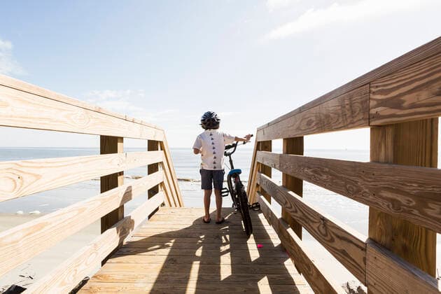 IMAGO Creative: Sommer Sport - Strand 6 year old boy on wooden bridge with his bike 6 year old boy on wooden bridge with his bike,St Simon s Island  61037