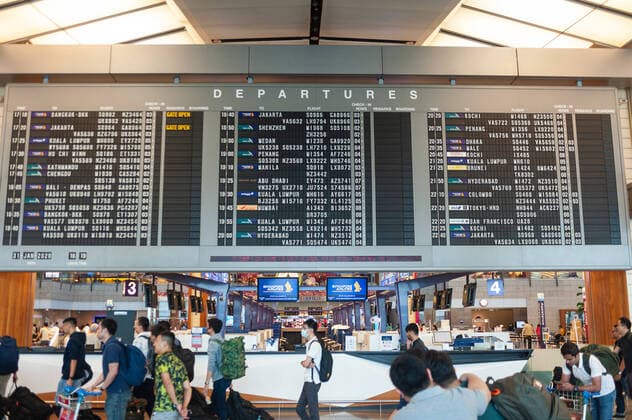 31.01.2020, Singapur, Republik Singapur, Asien - Flugreisende vor einer Anzeigetafel mit Fluginformationen in der Abflughalle des Terminal 2 am Flughafen Changi.