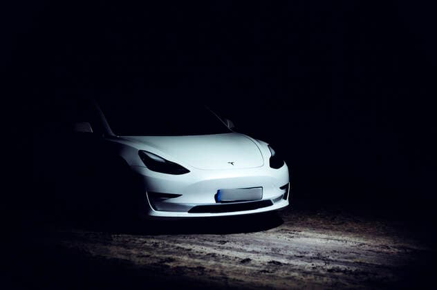 Ein Tesla Model 3, beleuchtet von einer Drohne, steht auf einem Waldweg nahe Grünheide. Grünheide, 19.01.2020