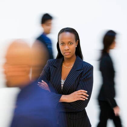 Businesswoman. African-American businesswoman standing with arms crossed while others walk by.  Copyright: xiofotox 35880