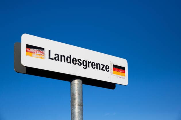 Schild Landesgrenze Deuschland vor blauem Himmel