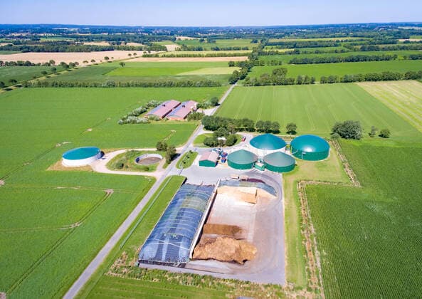 IMAGO Nature: Unsere Erde, Energiequellen, Biomasse Luftbild - Biogasanlage umgeben von Feldern - Frühjahr. Biogasanlage mit Maissilagelager und einigen Schweinemastställen im Hintergrund. Aufnahme mit einer Fotodrohne, eingerahmt in frischer, grüner Frühsommer-Landschaft. Biogasanlage zur Energieerzeugung in Form von Gas, welches im Generator in Strom umgewandelt wird und durch Nutzung der bei diem Prozess entstehenden Abwärme. Landkreis Osnabrück Niedersachsen Deutschland *** Aerial photo biogas plant surrounded by fields Spring biogas plant with maize silage storage and some pig fattening stables in the background Photo taken with a photo drone, framed in a fresh, green landscape in early summer Biogas plant for energy production in the form of gas, which is converted into electricity in the generator and by using the waste heat generated during the process District of Osnabrück