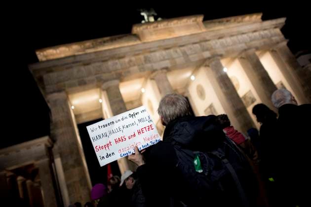 Vigil For Hanau Shooting Victims DEU, Deutschland, Germany, Berlin, 20.02.2020 Demonstranten mit Plakat Wir Trauern um Die Opfer von Hanau, Halle, Kassel, Moelln Stoppt Hass Und Hetze in den asozialen Medien Google, Facebook, Twitter auf der Kundgebung und Demonstration von Parteien und Initiativen in Gedenken und in Trauer zu den Morden in Hanau vor dem Brandenburger Tor in Berlin. Die Demo wurde spontan von einem grossen Buendnis von Parteien, Organisationen und Initiativen organisiert und richtet sich gegen das Erstarken von rechten Tendenzen und Parteien. Protestler with solidarity sign Wir Trauern um Die Opfer von Hanau, Halle, Kassel, Moelln Stoppt Hass Und Hetze in den asozialen Medien Google, Facebook, Twitter during a Vigil For Hanau Shooting Victims following yesterday shooting in Hanau at the Brandenburger Gate in Berlin on Feb