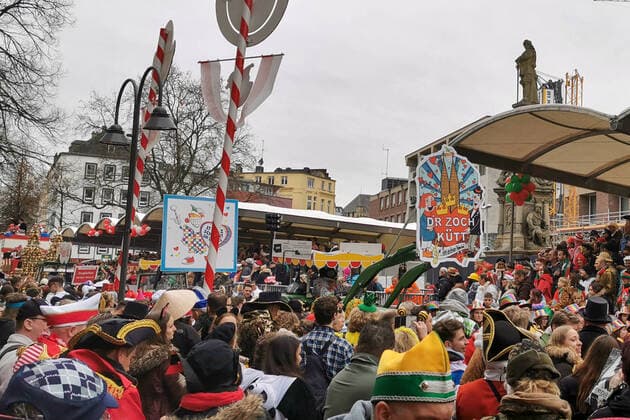 Schild D’r Zock kütt (Der Zug Kommt) am Anfang des Rosenmontagszug in Köln mit feiernden Menschen am Straßenrand Rosenmontagszug in Köln 2020, 24.02.20 Köln NRW Deutschland Alter Markt