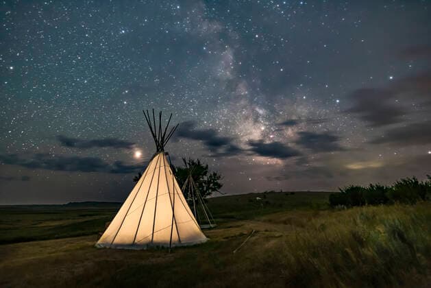 Mars (at left) and the Milky Way (at right) over a single tipi (with another under construction at back) at the Two Trees site at Grasslands National Park, Saskatchewan, August 6, 2018. I placed a low-level warm LED light inside the tipi for the illumination. This is a stack of 6 exposures, mean combined to smooth noise, for the ground, and one untracked exposure for the sky, all 30 seconds at f 2.2 with the 20mm Sigma lens and Nikon D750 at ISO 3200. Alberta Canada Copyright: xAlanxDyerx xVWPicsx ADY-OCT18-246