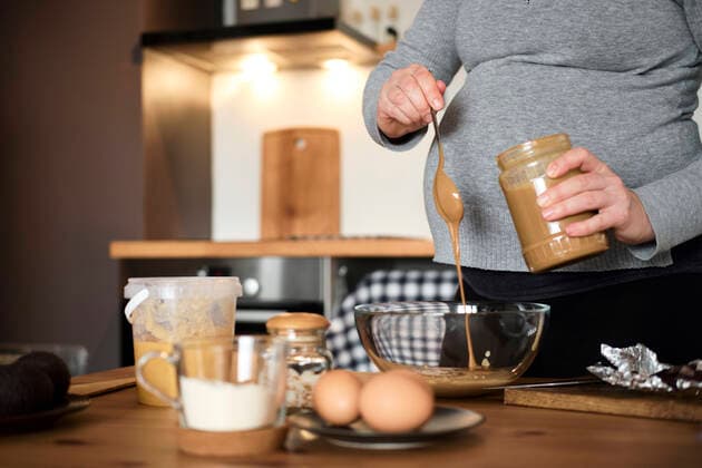 Pregnant woman making healthy cake with tahini, walnuts and dark chocolate at home model released Symbolfoto property released  BZF00513