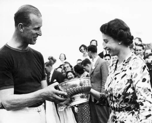 British Royalty. Duke of Edinburgh Prince Philip being presented a winning polo trophy by Queen Elizabeth II, Windsor Great Park, Windsor, England, 1961. Courtesy Everett Collection PUBLICATIONXNOTxINxCANxCHNxFRAxITAxJPNxNORxPOLxRUSxESPxUKxUSA Copyright: xCourtesyxEverettxCollectionx PBDQUEL EC071