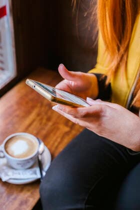 Crop view of young woman using smartphone in a coffee shop model released Symbolfoto property released  LJF01269