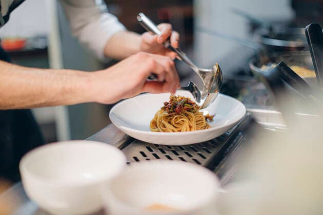 Chef preparing a dish in traditional Italian restaurant kitchen model released Symbolfoto property released  OCAF00451