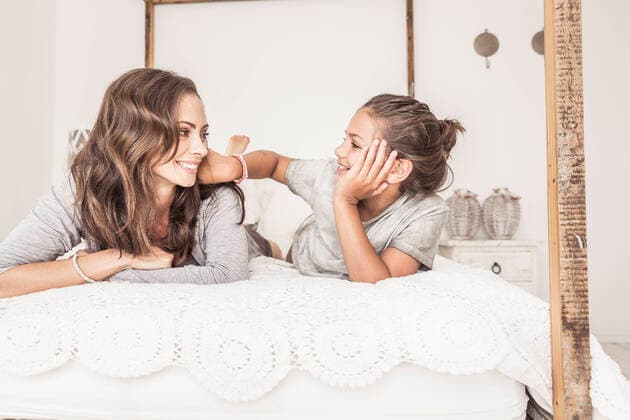 Mother and daughter lying together on bed relaxing model released Symbolfoto property released  SDAHF00220