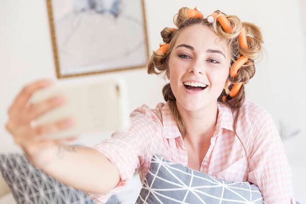Creative Highlights Symbolfotos Portrait of happy of young woman with curlers in hair taking selfie with smartphone model released Symbolfoto property released  SDAHF00438