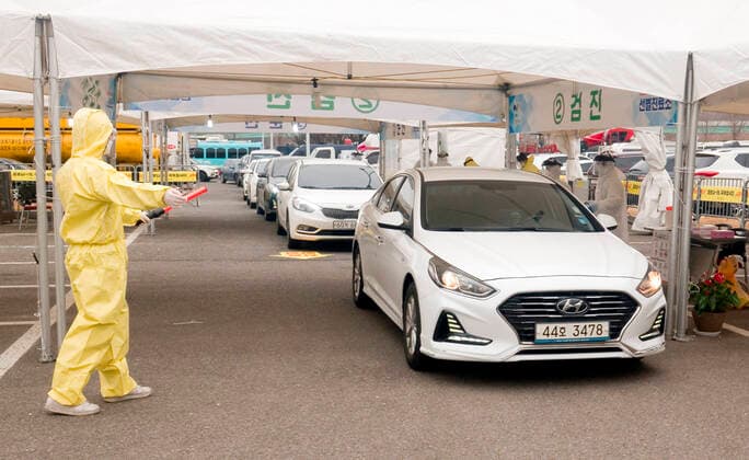 Drive-thru clinic testing of the COVID-19, Feb 28, 2020 : People in their cars arrive at a drive-thru clinic testing of the COVID-19 in Goyang, north of Seoul, South Korea. South Korea s local governments have introduced testing facilities where medical staff take samples from people in cars who have suspected symptoms of COVID-19. Drivers do not have to get out of their cars and they open a window to be checked for fever or have samples taken by medical staff in protective suits. Health authorities said the entire process takes about 10 minutes. South Korea reported 571 new cases of the coronavirus on Friday to bring the total number of infections to 2,337 as the country worked actively to counter the spreading virus with extensive testing, local media reported.  (123340518)