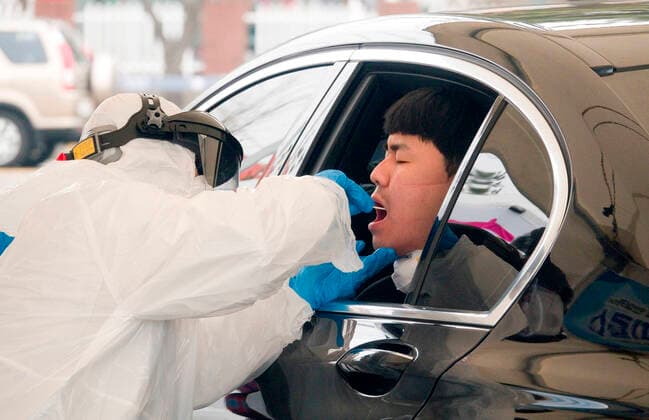 Drive-thru clinic testing of the COVID-19, Feb 28, 2020 : A medical staff gets samples at a drive-thru clinic testing of the COVID-19 in Goyang, north of Seoul, South Korea. South Korea s local governments have introduced testing facilities where medical staff take samples from people in cars who have suspected symptoms of COVID-19. Drivers do not have to get out of their cars and they open a window to be checked for fever or have samples taken by medical staff in protective suits. Health authorities said the entire process takes about 10 minutes. South Korea reported 571 new cases of the coronavirus on Friday to bring the total number of infections to 2,337 as the country worked actively to counter the spreading virus with extensive testing, local media reported.  (123342091)