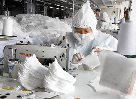 (200302) -- QINGDAO, March 2, 2020 -- Workers make face masks at the workshop of a garment company which has changed its production line to produce protective materials in Qingdao, east China s Shandong Province, March 2, 2020. China s daily output of face masks reached 116 million units as of Saturday, 12 times the figure reported on Feb. 1, as production expansion moves into top gear, official data showed Monday. By the end of February, the daily production capacity of masks in China more than quintupled from Feb. 1 to 110 million units that came in medical and non-medical calibers, the National Development and Reform Commission said. ) CHINA-FACE MASK-PRODUCTION CAPACITY-OUTPUT (CN) LixZiheng