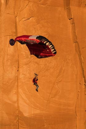 IMAGO Creative: Sport Dichotomien - Land und Wasser A BASE jumper descends in his parachute off the 400 foot vertical face of the Tombstone in Kane Springs Canyon near Moab, Utah. Moab Kane Springs Canyon Utah United States Copyright: xJonxG.xFullerx xVWPicsx JGF-sports-BASE Jumping-US-UT-0426