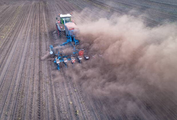 Agrarfoto - Luftaufnahme, Landtechnik bei großer Trockenheit im Einsatz. Maisbestellung mit starker Staubentwicklung. Luftaufnahme eines Schleppers mit Maislegegerät im Einsatz. Landkreis Osnabrück Niedersachsen Deutschland