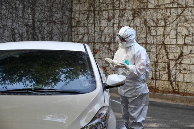 Health workers in biohazard suits treat patients at a drive-thru coronavirus testing center at Seoul Metropolitan Eunpyeong Hospital on March 4, 2020  SEO2020030448 THOMASxMARESCA