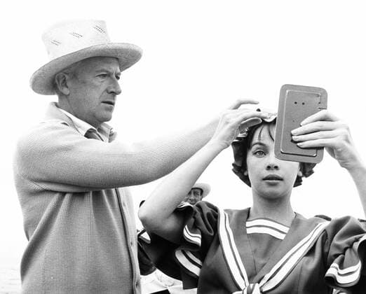 GIGI, Leslie Caron, having her bathing cap adjusted by costume designer Cecil Beaton, on-set, December 1957 Courtesy Everett Collection PUBLICATIONXNOTxINxCANxCHNxFRAxITAxJPNxNORxPOLxRUSxESPxUKxUSA Copyright: xCourtesyxEverettxCollectionx MBDGIGI EC057