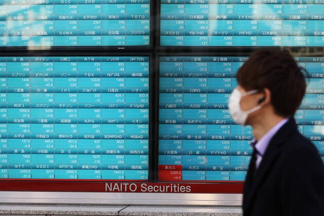 (200306) -- TOKYO, March 6, 2020 -- A passenger wearing a mask passes by an electronic board showing the stock index in Tokyo, Japan, on March 6, 2020. Tokyo stocks closed sharply lower Friday as investor sentiment was risk-averse from the outset following a global equities rout triggered by an escalation in concern over the spread of the coronavirus. ) JAPAN-TOKYO-STOCK DuxXiaoyi 