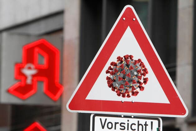 (Fotomontage) Symbolbild zur Ausbreitung des Coronavirus und der öffentliche Umgang mit der Krankheit: Verkehrsschild Achtung Coronavirus mit Zusatz Vorsicht vor dem Logo einer Apotheke in Frankfurt, Hessen, Deutschland