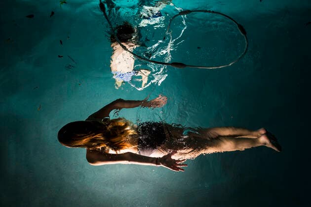 Two children swimming in pool at night Two children swimming in pool at night  61173