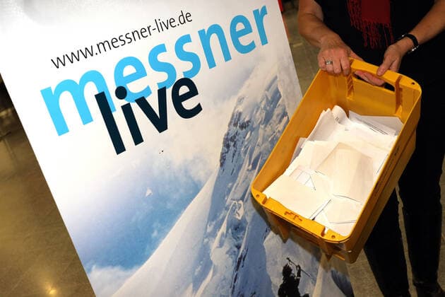 Eine Kiste voll mit Registrierungskarten der Besucher vor einem Aufsteller Messner live Praeventionsmassnahme wegen des Coronavirus in der Siegerlandhalle in Siegen, die Veranstaltung mit Reinhold Messner findet unter Auflagen statt. Jeder Besucher der Veranstaltung muss eine Registrierungskarte ausfuellen Mittwoch 11.03.2020, Reinhold Messner: Nanga Parbat - Mein Schicksalsberg in der Siegerlandhalle in Siegen
