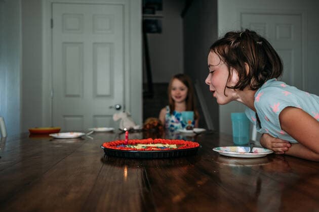 Geburtstag - Symbolbilder Creative Highlights Symbolfotos side view of girl blowing out a candle on birthday cake Denver, CO, United States ,model released, Symbolfoto CR_JEMI200115I-277642-01