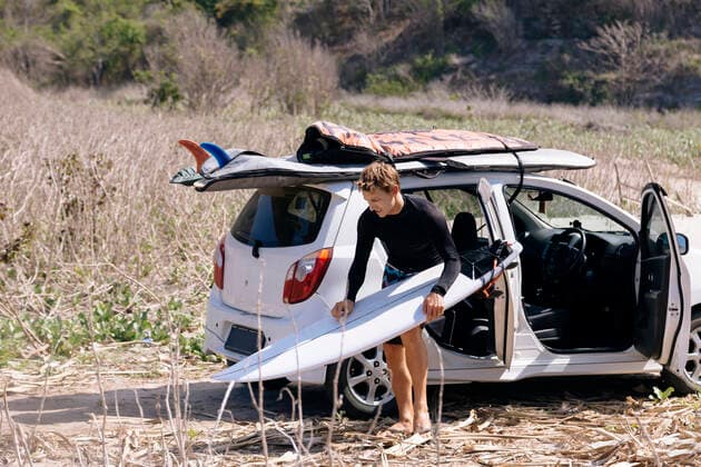 IMAGO Creative: Ende des Sommers Young man with surfboard near car Sumbawa Sub-District, West Nusa Tenggara, Indonesia ,model released, Symbolfoto CR_KOTRIN200115C-261935-01