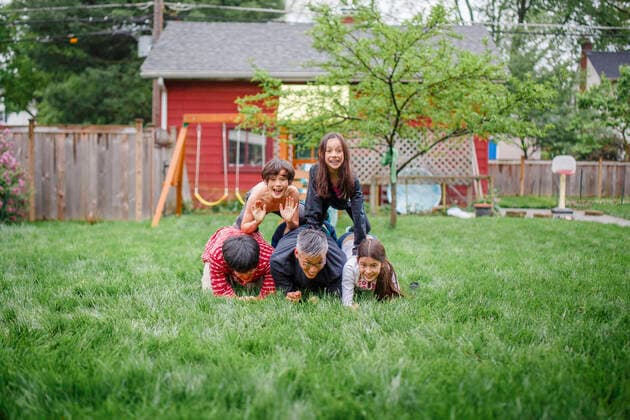 A smiling family are stacked up in human pyramid in backyard play Columbus, OH, United States ,model released, Symbolfoto CR_RETI200120B-250649-01