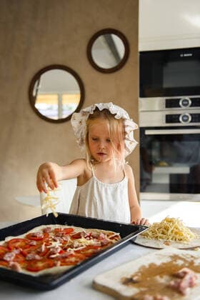 Little girl cooking pizza in the kitchen Rome, Lazio, Italy ,model released, Symbolfoto CR_YUKI200123B-225491-01