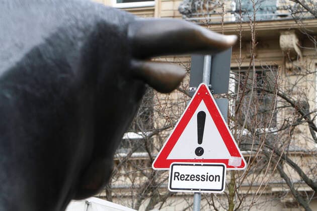 (Fotomontage) Symbolbild zum Thema Kurssturz an den Börsen und Verfall des Aktienindexes DAX: Bronzeskulptur des Bulle n vor der Wertpapierbörse Frankfurt, der symbolhaft für steigende Kürse an der Börse steht, schaut auf ein Verkehrsschild Achtung Gefahr und Zusatz Rezession, Hessen, Deutschland *** Photomontage symbolic image on the theme of falling prices on the stock markets and the decline of the DAX stock index Bronze sculpture of the bull n in front of the Frankfurt Stock Exchange, symbolizing rising freestyle on the stock market, looking at a traffic sign Attention Danger and additional recession, Hesse, Germany