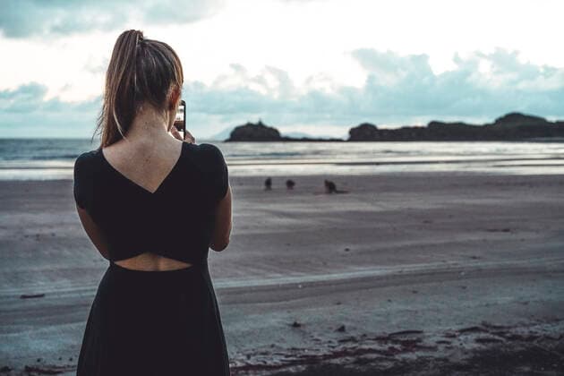 Rear view of young woman taking pictures of kangaroos at beach Cape Hillsborough, QLD, Australia ,model released, Symbolfoto CR_MAKO200128A-303299-01