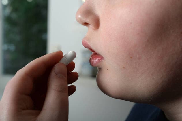 Junge muss wegen einer Mittelohrentzündung ein Antibiotikum nehmen.