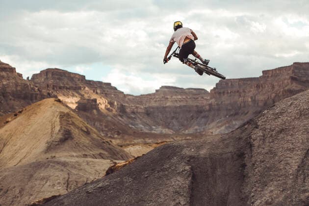 Rear view of young male jumping with mountain bike in desert landscape Green River, UT, United States ,model released, Symbolfoto CR_MAKO200210A-304969-01