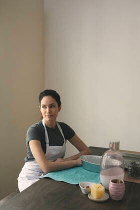 Thoughtful woman in apron sitting with containers and ingredients for preparing food at home Los Angeles, CA, United States ,model released, Symbolfoto CR_JAJEES200212-305444-01
