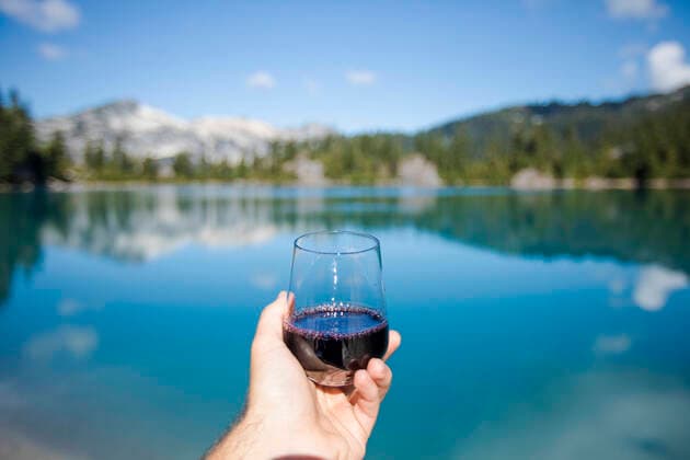 Man holds glass or red wine at the lake. Vancouver, BC, Canada ,model released, Symbolfoto CR_JDIP200213-303857-01